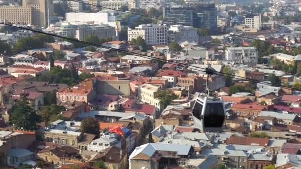 Linbanevagn hänger ovanför staden Tbilisi i Georgien med utsikt över gamla byggnader på bakgrund, resor och turism koncept — Stockvideo