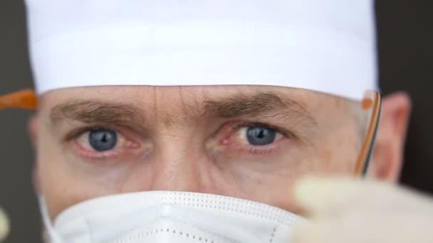 Overwerkte gezondheidswerkers met een beschermend masker op het gezicht. Mentale toestand van de arts na het innemen van een groot aantal patiënten als gevolg van de epidemie van het coronavirus. — Stockvideo