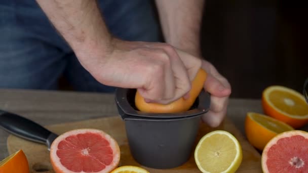 Mužské ruce mačkají zralé grapefruity pro výrobu citrusové šťávy, zdravého životního stylu, ovocné šťávy — Stock video