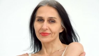 Orta yaşlı bir kadının portresi beyaz arka planda çıplak omuzlarla stüdyoda saçlarını ağartmaya başlıyor, yüz bakımı güzelliği, orta yaşlı kozmetik ürünleri, kozmetik konsepti