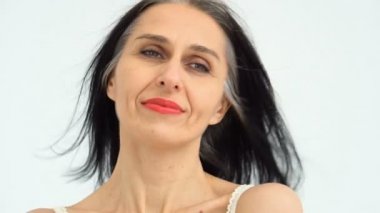 Orta yaşlı bir kadının portresi beyaz arka planda çıplak omuzlarla stüdyoda saçlarını ağartmaya başlıyor, yüz bakımı güzelliği, orta yaşlı kozmetik ürünleri, kozmetik konsepti