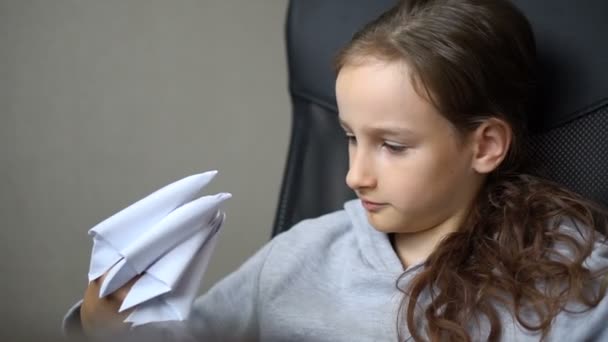 Menina loira está brincando com origami, garras de papel de dragão, criação de dragões de papel, conceito de arte infantil. — Vídeo de Stock