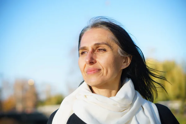 Perfil vista lateral retrato de atractiva mujer de mediana edad alegre de pelo gris soñadora relajándose al aire libre durante el día soleado — Foto de Stock