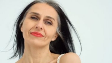 Orta yaşlı bir kadının portresi beyaz arka planda çıplak omuzlarla stüdyoda saçlarını ağartmaya başlıyor, yüz bakımı güzelliği, orta yaşlı kozmetik ürünleri, kozmetik konsepti