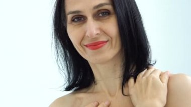 Orta yaşlı bir kadının portresi beyaz arka planda çıplak omuzlarla stüdyoda saçlarını ağartmaya başlıyor, yüz bakımı güzelliği, orta yaşlı kozmetik ürünleri, kozmetik konsepti