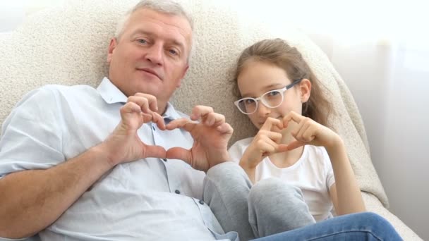 Dojrzały przystojny mężczyzna i mała blondynka dziewczyna pokazują serca przez ręce, szczęśliwa rodzina, razem, ojcowie dni koncepcje — Wideo stockowe