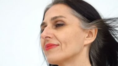Orta yaşlı bir kadının portresi beyaz arka planda çıplak omuzlarla stüdyoda saçlarını ağartmaya başlıyor, yüz bakımı güzelliği, orta yaşlı kozmetik ürünleri, kozmetik konsepti