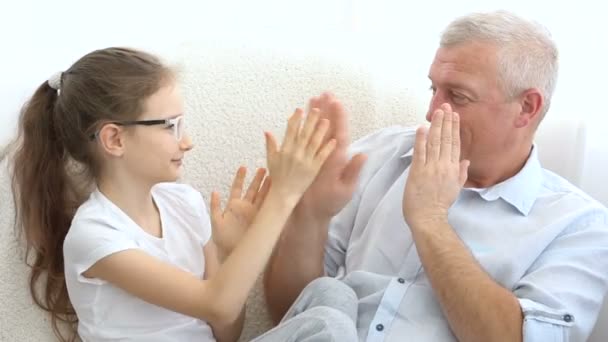 Retrato interno de pai de cabelos grisalhos e menina loira brincando uns com os outros em casa, conceito de dia dos pais. — Vídeo de Stock