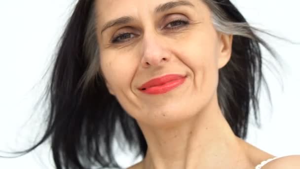 Vrouwelijke portret van middelbare leeftijd vrouw beginnen steeds grijs-harig in studio met naakte schouders op witte achtergrond, gezichtsverzorging schoonheid, middelbare leeftijd huidverzorging cosmetica, cosmetologie concept — Stockvideo