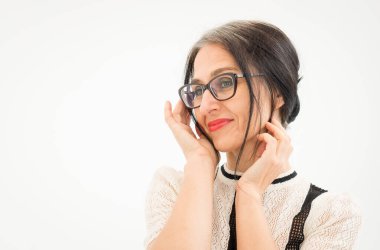 Stüdyo fotoğrafında orta yaşlı bir kadın beyaz arka planda siyah beyaz elbiseler giyerek saçlarını ağartmaya başlıyor. Orta yaşlı seksi kadın, mutlu yaşam kavramı.