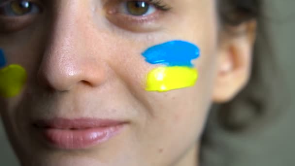 Retrato interno de jovem com bandeira ucraniana azul e amarela na bochecha vestindo uniforme militar, recrutamento obrigatório na Ucrânia, conceitos de igualdade — Vídeo de Stock