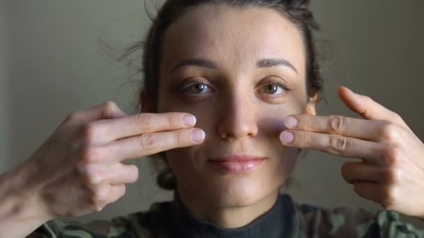 Fiatal lány fáj kék és sárga ukrán zászló az arcán az ujjai viselése katonai egyenruha, kötelező besorozás Ukrajnában, egyenlőség fogalmak — Stock videók