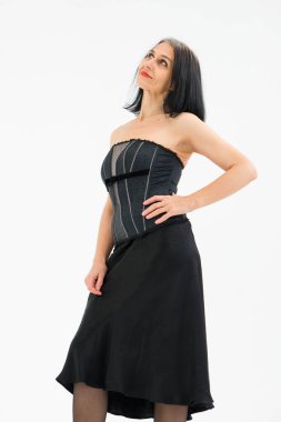 Orta yaşlı bir kadının saçları ağarmaya başlıyor. Stüdyoda siyah kıyafetler ve beyaz arka planda çoraplarla poz veriyor. Orta yaşlı seksi bayan, kozmetoloji konsepti.