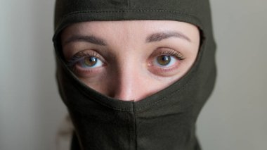 Haki kar maskesi giyen genç bir kızın kadın portresi, sadece gözler görünür, zorunlu askere alınma, askerlik, feminizm, eşitlik kavramı