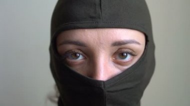 Haki kar maskesi giyen genç bir kızın kadın portresi, sadece gözler görünür, zorunlu askere alınma, askerlik, feminizm, eşitlik kavramı