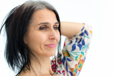 Orta yaşlı bir kadının portresi beyaz arka planda çiçekli gri saçlar giymeye başlıyor. Orta yaşlı seksi bayan, kozmetoloji konsepti.