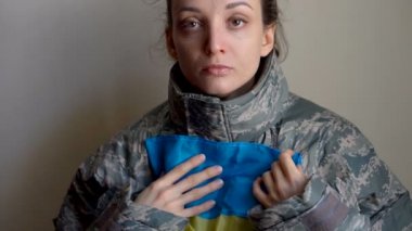 Genç bayan asker Ukrayna 'nın batı kesimindeki gerginlik, Rus işgali ve savaş konsepti nedeniyle Ukrayna bayrağını sevgi ve endişeyle taşıyor.