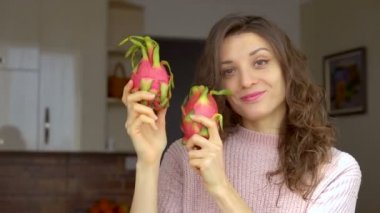 Genç kız iki taze organik ejderha meyvesi ya da pitaya, pitahaya tutuyor. Egzotik meyveler, sağlıklı beslenme konsepti