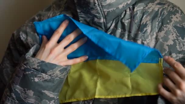 Joven soldado mantiene bandera ucraniana con amor y ansiedad debido a la escalada del conflicto militar en la parte occidental de Ucrania, invasión rusa, concepto de guerra — Vídeo de stock