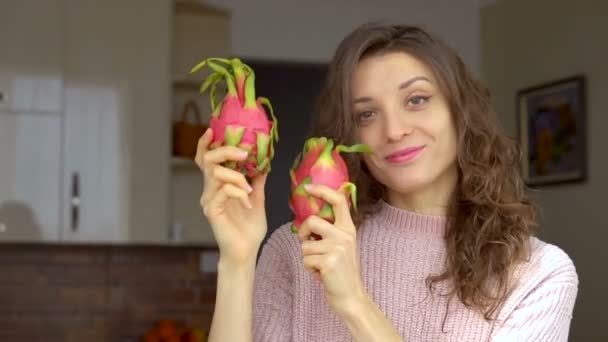 Jeune fille tient deux fruits du dragon biologiques mûrs frais ou pitaya, pitahaya. Fruits exotiques, concept de saine alimentation — Video