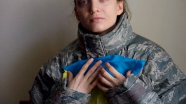 Genç bayan asker Ukrayna 'nın batı kesimindeki gerginlik, Rus işgali ve savaş konsepti nedeniyle Ukrayna bayrağını sevgi ve endişeyle taşıyor.