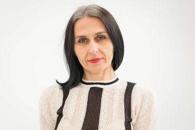 Stüdyo fotoğrafında orta yaşlı bir kadın beyaz arka planda siyah beyaz elbiseler giyerek saçlarını ağartmaya başlıyor. Orta yaşlı seksi kadın, mutlu yaşam kavramı.