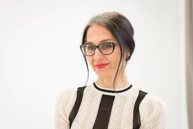 Stüdyo fotoğrafında orta yaşlı bir kadın beyaz arka planda siyah beyaz elbiseler giyerek saçlarını ağartmaya başlıyor. Orta yaşlı seksi kadın, mutlu yaşam kavramı.