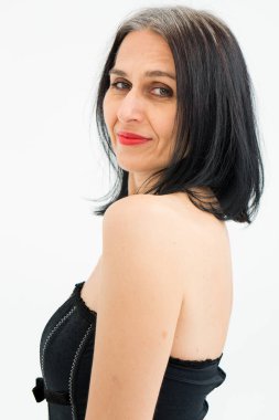 Orta yaşlı bir kadının saçları ağarmaya başlıyor. Stüdyoda siyah kıyafetler ve beyaz arka planda çoraplarla poz veriyor. Orta yaşlı seksi bayan, kozmetoloji konsepti.