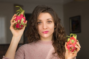 Genç kız iki taze organik ejderha meyvesi ya da pitaya, pitahaya tutuyor. Egzotik meyveler, sağlıklı beslenme konsepti