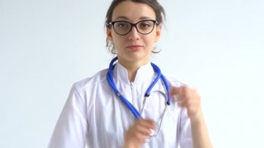 Kadın doktor, bazı tıbbi manipülasyonlar ve aşılardan sonra beyaz arka plana izole edilmiş koruyucu mavi eldivenleri erteliyor..