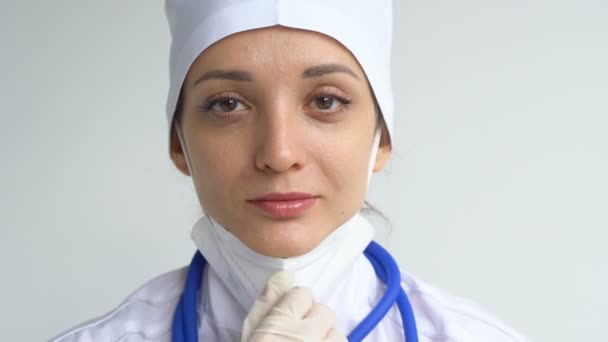 Kvinna läkare skjuter upp skyddande blå handskar isolerad på vit bakgrund efter vissa medicinska manipulationer, vaccination. — Stockvideo