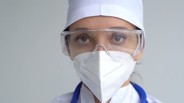 Nainen lääkäri lykkää suojaava sininen käsineet eristetty valkoisella pohjalla jälkeen joitakin lääketieteellisiä manipulaatioita, rokotus. — kuvapankkivideo