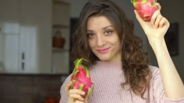 Genç kız iki taze organik ejderha meyvesi ya da pitaya, pitahaya tutuyor. Egzotik meyveler, sağlıklı beslenme konsepti