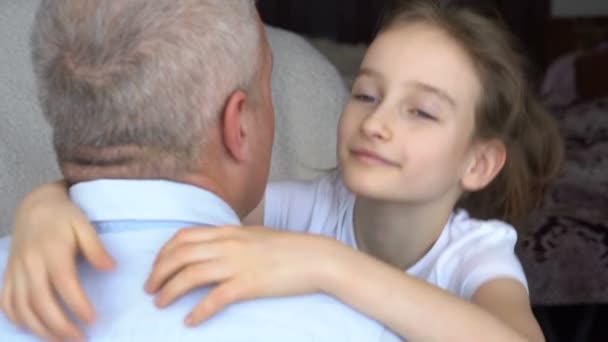 Familie portret van volwassen vader en kleine blonde dochter knuffelen thuis, terwijl vieren vaders dag — Stockvideo