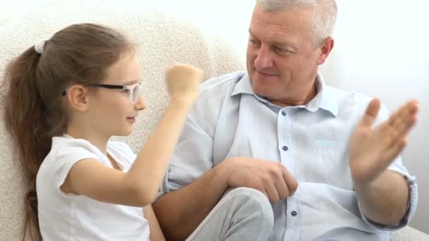 Innenporträt des grauhaarigen Vaters und des kleinen blonden Mädchens, die zu Hause miteinander spielen, Vatertagskonzept. — Stockvideo