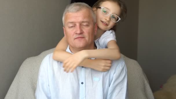 Familie portret van volwassen vader en kleine blonde dochter knuffelen thuis, terwijl vieren vaders dag — Stockvideo