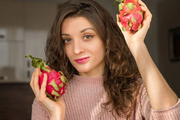 Rapariga está segurando duas frutas frescas maduras dragão orgânico ou pitaya, pitahaya. Frutas exóticas, conceito de alimentação saudável — Fotografia de Stock