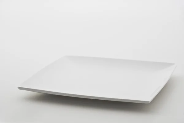 Фарфоровая тарелка на белом фоне — стоковое фото
