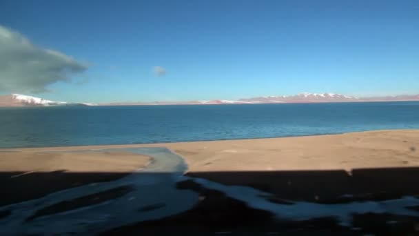 광대 한 사막 및 티베트에 호수를 통해 이동 하는 열차의 슬로우 모션 — 비디오