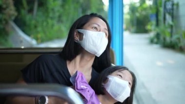 Asian Asia mother and daughter enjoying rail ride at sentosa, Singapore with mask on