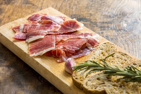 Spanish ham with toasts, focus on ham — Stock Photo, Image