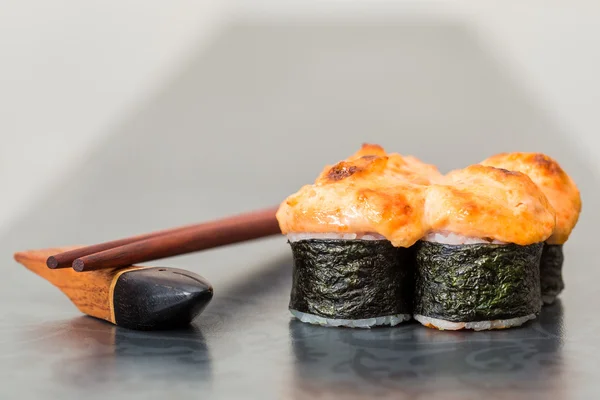 Bakade sushi rulle på grå bakgrund — Stockfoto