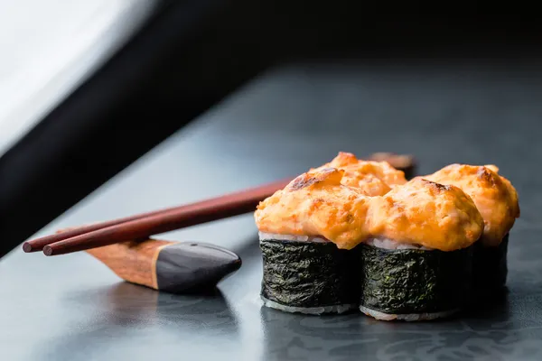 Bakad sushi rulle på mörk bakgrund — Stockfoto