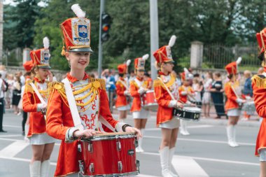 Ternopil, Ukrayna 2 Temmuz 2021: Geçit töreninde kırmızı üniformalı genç kız davulcu. Sokak performansı. Majorette 'lerin geçit töreni