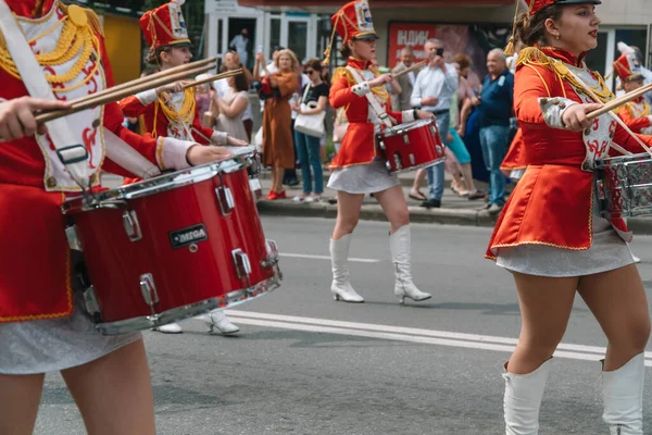 Ternopil, Ukrayna 2 Temmuz 2021: Geçit töreninde kırmızı üniformalı genç kız davulcu. Sokak performansı. Majorette 'lerin geçit töreni