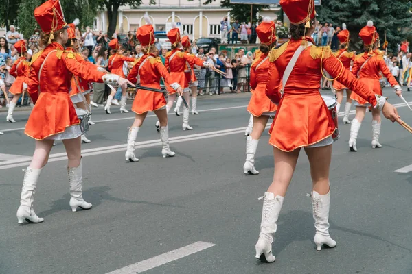 Ternopil, Ukrayna 2 Temmuz 2021: Geçit töreninde kırmızı üniformalı genç kız davulcu. Sokak performansı. Majorette 'lerin geçit töreni