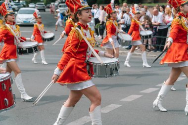 Ternopil, Ukrayna 2 Temmuz 2021: Geçit töreninde kırmızı üniformalı genç kız davulcu. Sokak performansı. Majorette 'lerin geçit töreni