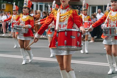 Ternopil, Ukrayna 2 Temmuz 2021: Geçit töreninde kırmızı üniformalı genç kız davulcu. Sokak performansı. Majorette 'lerin geçit töreni