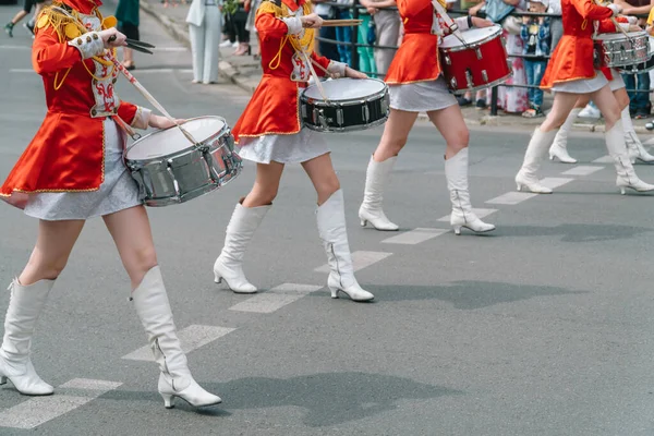 Street performance. Close-up of female drummers hands in red vintage uniform at the parade