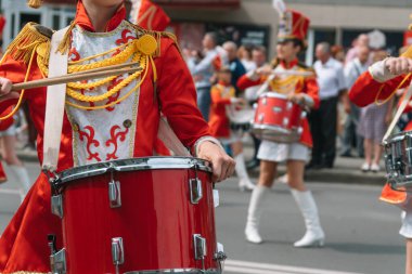 Ternopil, Ukrayna 2 Temmuz 2021: Geçit töreninde kırmızı üniformalı genç kız davulcu. Sokak performansı. Majorette 'lerin geçit töreni